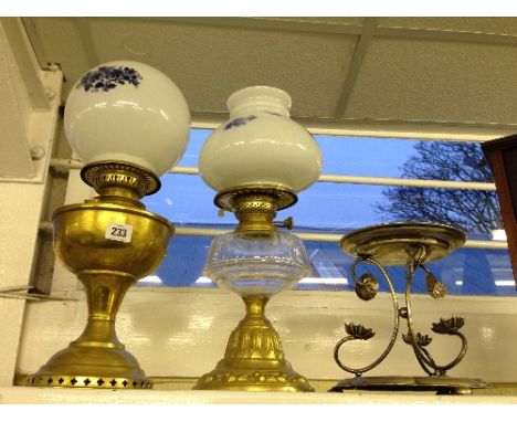 A brass oil lamp with cut glass well together with a brass oil lamp and a silver plated cake stand.