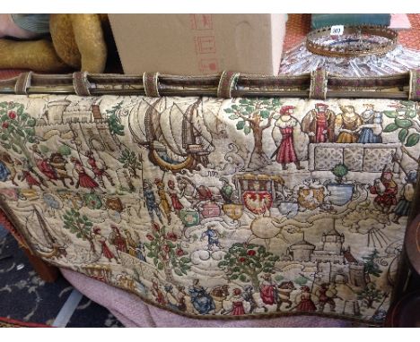 A Flemish style embroidered tapestry wall hanging on brass rail.