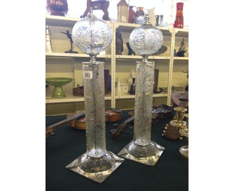 A pair of engraved glass lamp bases decorated with stylised flowers.