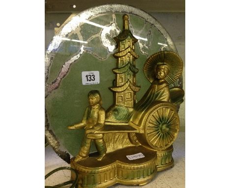 An Art Deco gold painted metal table lamp, modelled as Chinese figures in a rickshaw with a tower behind with original glass 