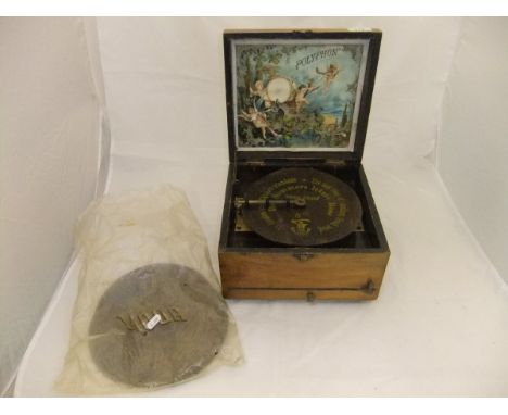 A walnut cased table top polyphon, bearing original lithographed paper label, together with six various disks