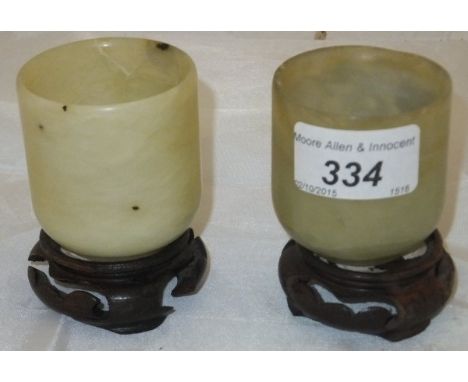 A pair of Chinese jade beakers CONDITION REPORTS Beakers attached to bases. Some chips to the rims. One base with losses. Gen