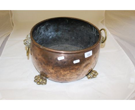 A Victorian copper and brass embellished coal container with lion mask ring handles on lions paw feet