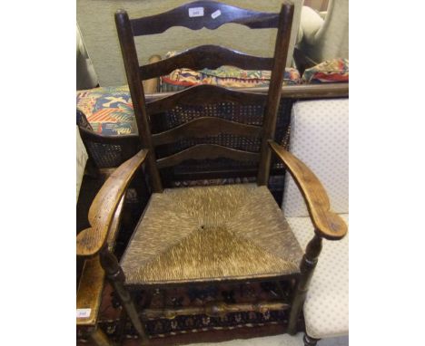 A 19th Century elm rush seat ladder back elbow chair