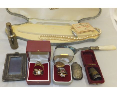 A box containing various 9 carat gold and other rings, a gold coloured heart shaped locket, string of pearls, two thimbles, a