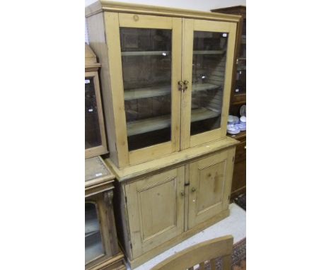 A Victorian pine dresser, the two door glazed cabinet top with adjustable shelving over two panelled cupboard doors enclosing