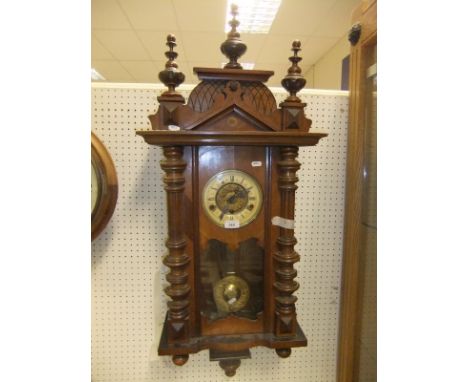 A walnut cased Vienna regulator type wall clock, the enamelled chapter ring bearing Roman numerals, the case with turned and 