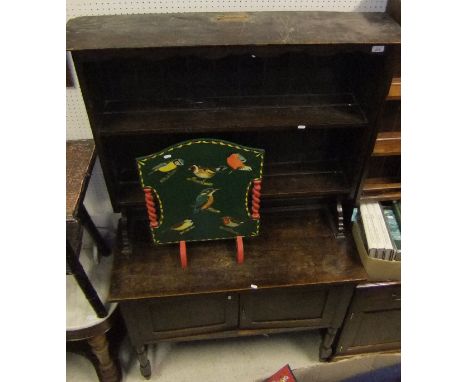 An oak dresser with two tier open plate rack over two cupboard doors and a painted and bird print decoration fire screen