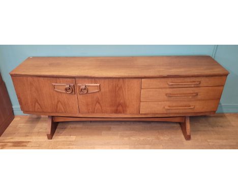 Beautility: A mid 20th century teak sideboard credenza/drinks cabinet, of rectangular form with shallow concave front, a cent