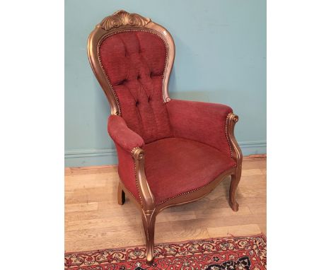 A French Empire style bedroom chair, the gilt wood frame with button back upholstery, scrolled arms on cabriole front legs, H