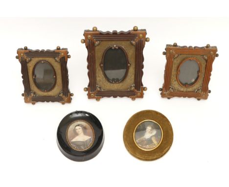 Five photograph frames, to include, three brass examples with etched florals and fauna, and two oval frames housing miniature