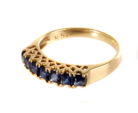 A 18ct seven stone ring, the seven square cut blue stones in pierced design mount, on 18ct gold band, size K, approx 2.5g