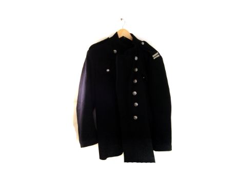 A vintage Sub-Officer fire fighting tunic, together a firemen's example, plus a pair of yellow over-trousers and a fire axe a