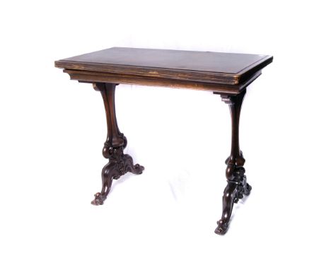A walnut Gothic card table, the quartered veneer swivel and fold out top reveals green felt playing surface on carved and pie