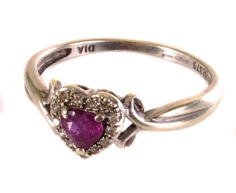 A 9ct white gold, ruby and diamond ring, the heart cut ruby stone, in three claw mount, surrounded by small round cut diamond