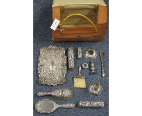 Lady's carrier bag containing silver repousse scroll decorated vanity set comprising: tray; candle sticks; brushes; mirror; s