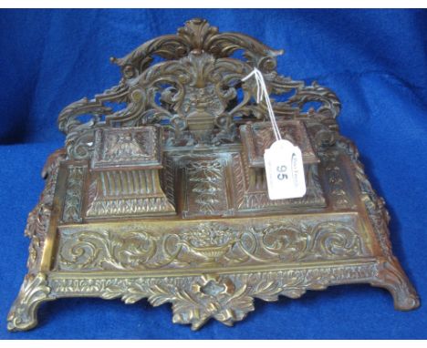 Brass desk stand and inkwell with overall scrolled foliate decoration, two lidded inkwells with ceramic liners. 30cm wide app
