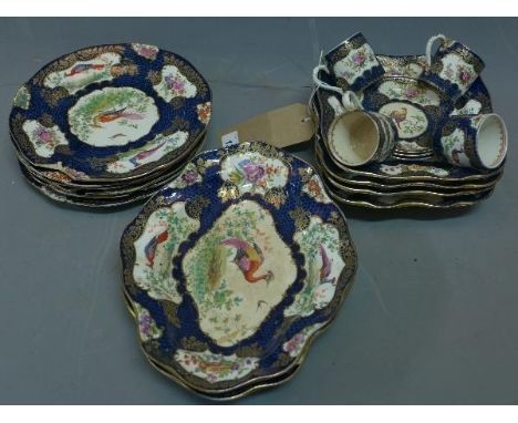 A 19th century English hard paste porcelain part dinner service, decorated with birds on a cobalt blue ground with gilt highl