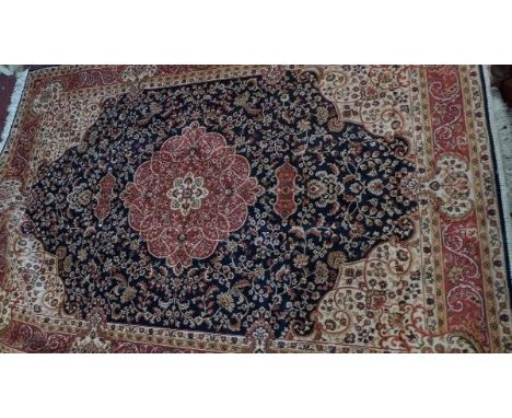 A Kashan style carpet, with central floral medallion, on a blue ground, contained by floral borders. 230x160cm 