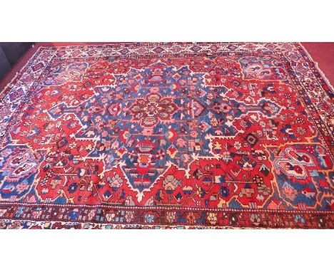 A fine North West Persian Hriz carpet, 370cm x 300cm, central double pendent medallion on a terracotta field within ivory flo