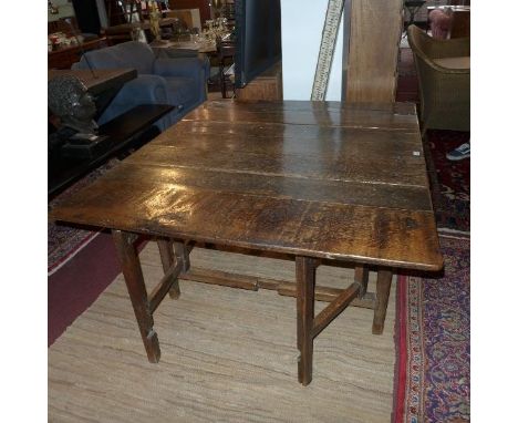 An early 19th century oak drop leaf, gate leg, dining table. 
