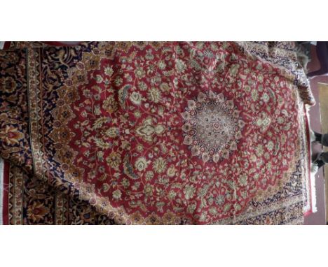 A Kashan style carpet with central floral medallion on a red ground contained by repeating floral borders. 280 x 200cm 