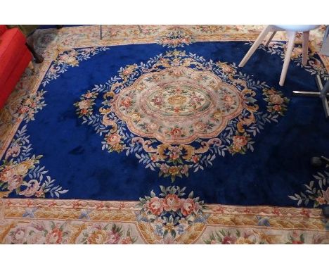 A large Chinese woolen carpet with central floral medallion on a blue ground contained by floral border. 370 x 272cm 