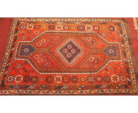 A Quashqai Shiraz carpet with central lozenge geometric medallion on an orange ground contained by geometric borders. 245 x 1