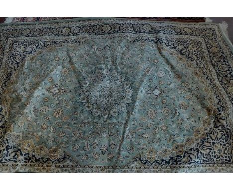 A Kashan style carpet, with central floral medallion, on a green ground, contained by floral borders. 230 x 160cm 