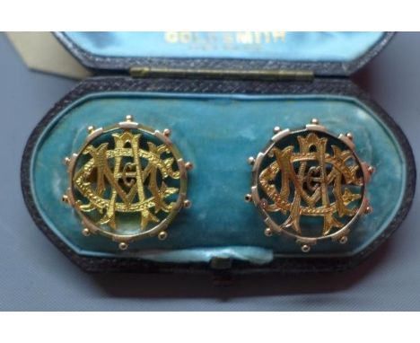A pair of 15ct yellow gold cufflinks, in the form of ship's wheel with monogram to centre, marked 15ct and bearing maker's ma