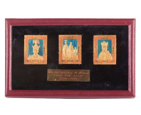 A set of three Iranian gold and enamel pictorial stamps, approximately 21ct gold, commemorating the coronation of Mohammad Re