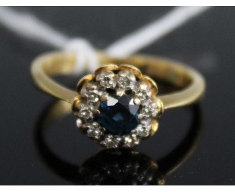 An 18ct gold sapphire and diamond flowerhead cluster ring, 4.1g, size N/OCondition report: Very small chip to edge of diamond