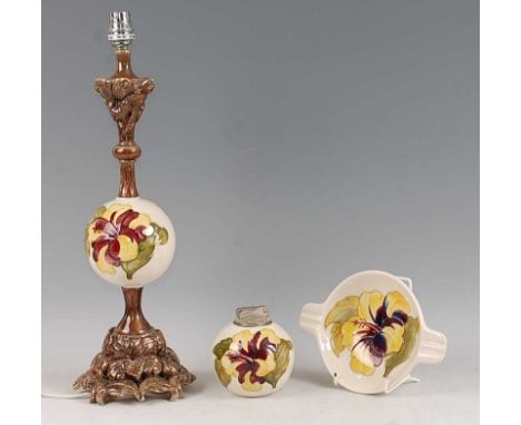 A Moorcroft Hibiscus pattern pottery table lamp, having globe shaped column being floral and silvered decorated, with shade, 