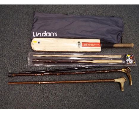 A good mixed lot to include three walking sticks, a snooker cue (boxed), a Grey - Nicolls cricket bat and a Lindam stair gate