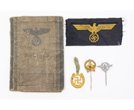 A WWII German Workpass, dated 11th May 1944, together with  a cloth patch and three gilt  NSDAP lapel badges.