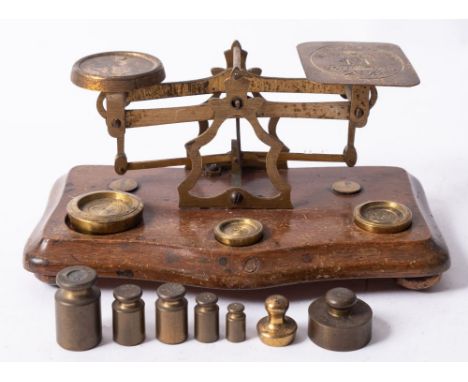 A set of early 20th century mahogany and brass postal scales and weights.