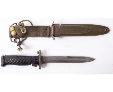 An American M5 pattern bayonet, the  straight clipped back blade over a two piece black plastic chequered grip in a scabbard 