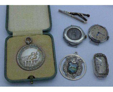 Three watches, a silver gilt tie-clip, a silver and enamel medallion and a silver life saving medallion, two watches lacking 