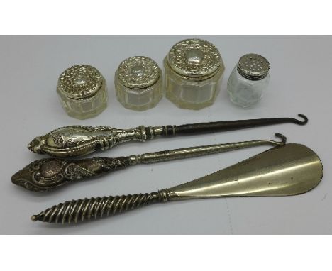 Three silver top jars, a silver top pepper, two silver handled button hooks and a silver handled shoe horn