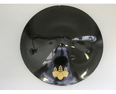 A JINGASA (WAR HAT) OF LIGHT WOOD COVERED WITH BLACK LACQUER, CIRCA 1750-1850bearing a gold lacquered mon (family crest) of a