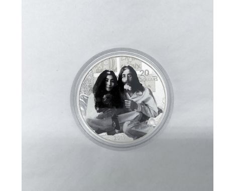 The obverse side depicts the profile of Queen Elizabeth II facing right. The reverse side is a rendition of a photograph of J