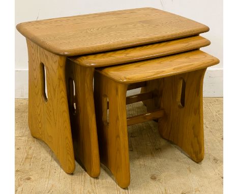 A nest of three Ercol elm tables, with rectangular tops on shaped supports, 45cm x 63.5cm x 41cm 