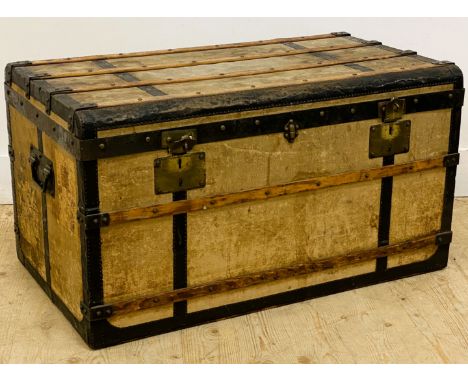 A continental travel trunk, of canvas and banded wood construction with metal side carrying handles, the lift up lid revealli