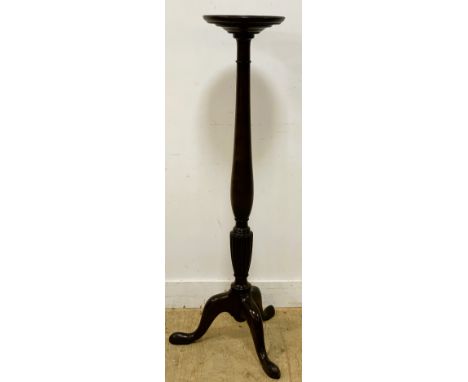 A mahogany torchere, raised on a tripod base with a turned column and circular top, 141cm high 