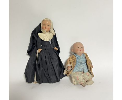 An early 20th Century bisque head doll with fixed brown eyes and painted features dressed as a nun (h. 29cm) together with a 