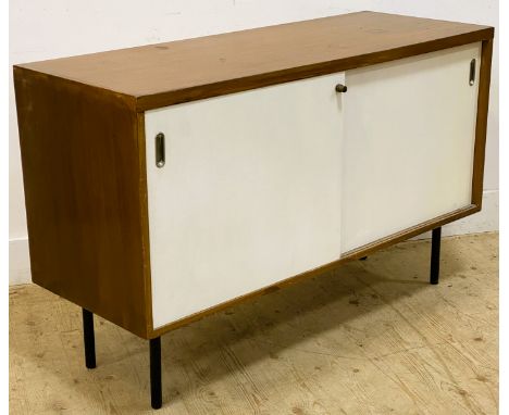 A teak sideboard, with a rectangular top above two white sliding doors opening to reveal a shelf, standing on metal tubular s