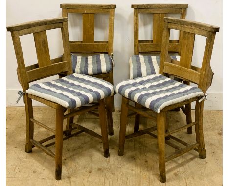 A set of four elm chapel chairs, each with a shaped top rail above a plain central splat with a rear book trough and solid se