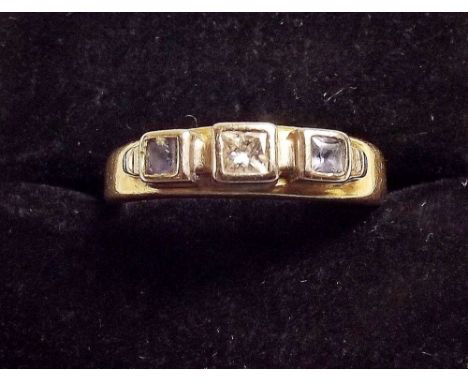An 18ct gold ring set diamond flanked by Ceylon sapphires 6.5g