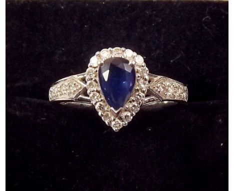 An 18 carat gold ring set pear form sapphire within diamond surround and on diamond set band