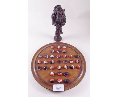A 19th century continental carved wood figurative nut cracker and a solitaire board